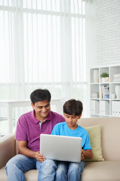 Padre e hijo viendo la película en el ordenador portátil — Foto de Stock