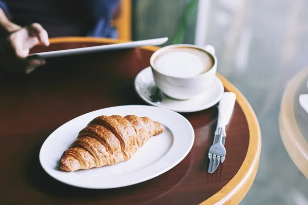 Frisches Croissant und Cappuccino — Stockfoto