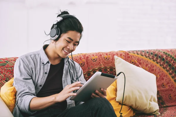 Kille som lyssnar på musik i tablett — Stockfoto