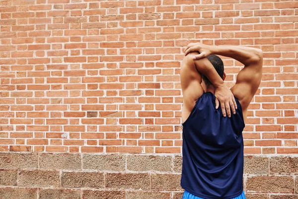 Sportsman stretching arms outdoors — Stock Photo, Image