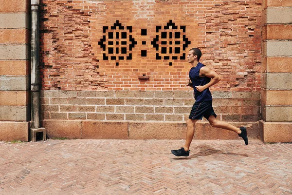 Uomo che fa jogging per strada al mattino — Foto Stock