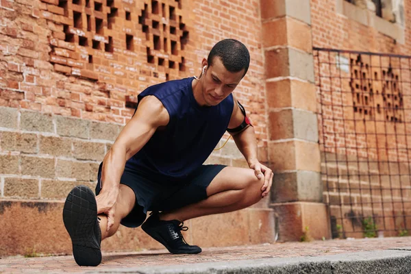 Man stretching benen na het joggen — Stockfoto