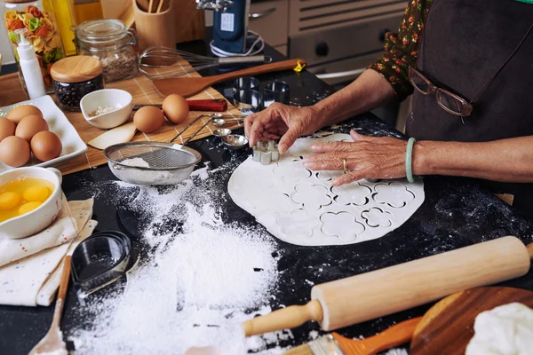 Mulher usando cortador para fazer belos biscoitos — Fotografia de Stock