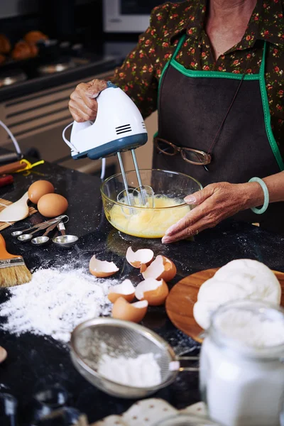 Kvinne som hvisker egg med blander – stockfoto