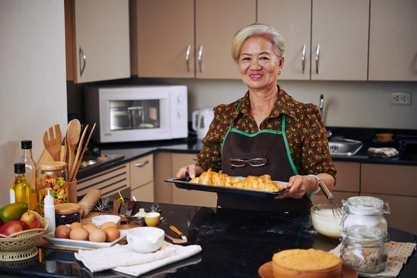 Femme au foyer avec plateau de croissants frais — Photo