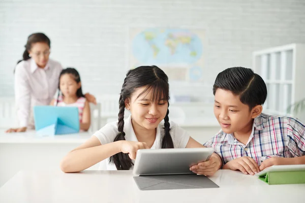 Compañeros de clase viendo algo en la pantalla de la tableta —  Fotos de Stock