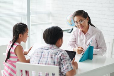 Bir şey tablete açıklayan öğretmen