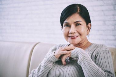 Gülümseyen kadın kameraya bakıyor.