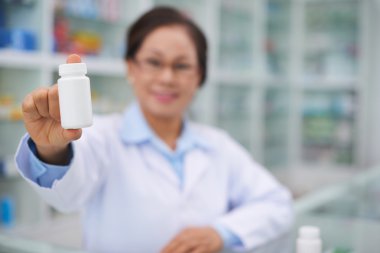 Eczacı gösteren şişe vitaminler ile