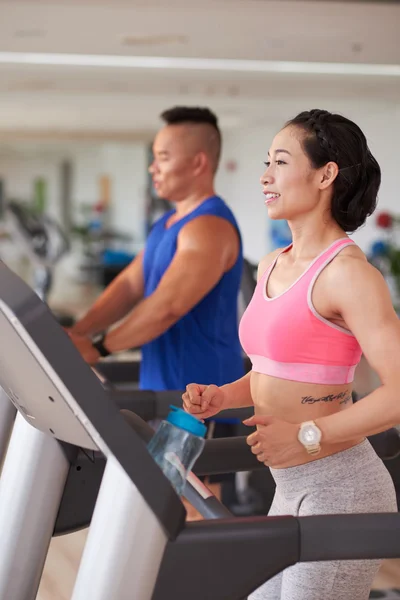 Mensen joggen op een loopband in sportclub — Stockfoto