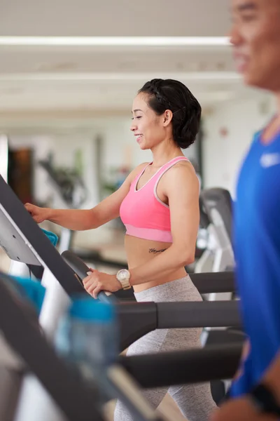 Deportista cambiando el nivel de velocidad en la cinta de correr — Foto de Stock