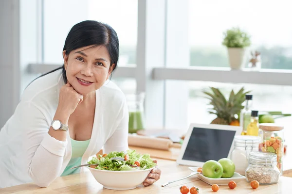 Žena jí doma zdravý salát — Stock fotografie