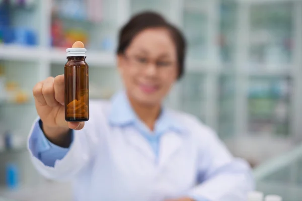 Lékárník drží láhev s lékařské řešení — Stock fotografie