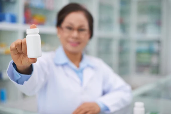 Farmacista che mostra bottiglia con vitamine — Foto Stock