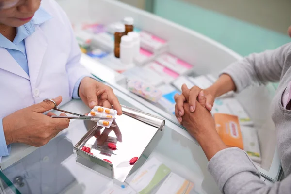 Drugstore worker selling medications to customer — Stock Photo, Image