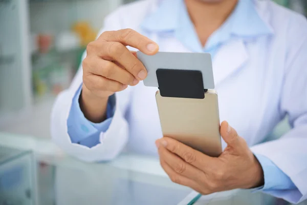 Händerna på apotekspersonal att svepa kreditkort — Stockfoto
