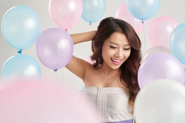 Ragazza in piedi tra palloncini colorati — Foto Stock