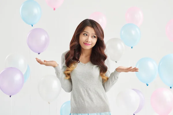 Mujer joven confundida y globos — Foto de Stock