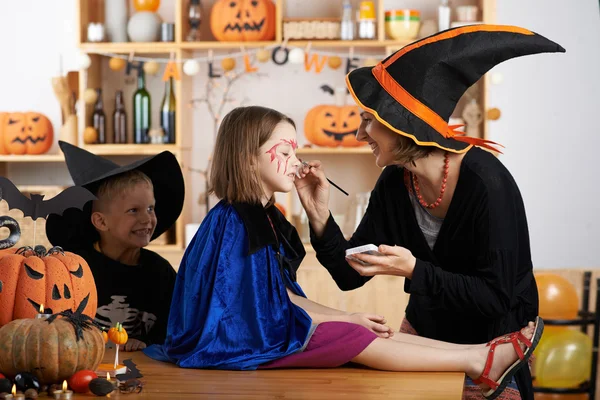 Teacher painting face of little girl — Stock Photo, Image