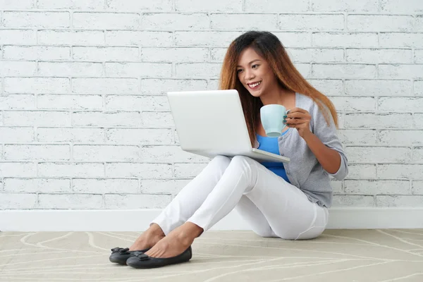 Vrouw met cup kijken tv toont — Stockfoto