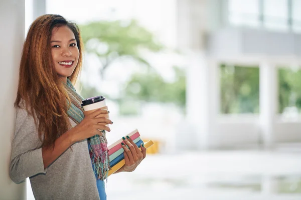 Student med kaffe och trave böcker — Stockfoto