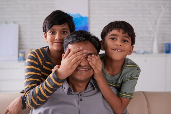 Kids covering eyes of father — Stock Photo, Image