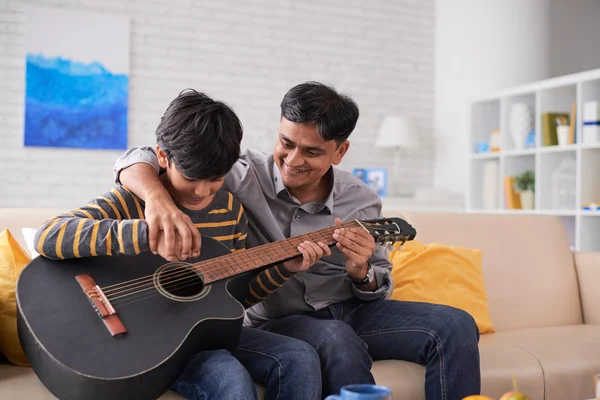 Père enseigne fils à jouer de la guitare — Photo