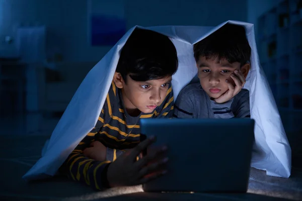 Дети смотрят фильмы на планшете — стоковое фото