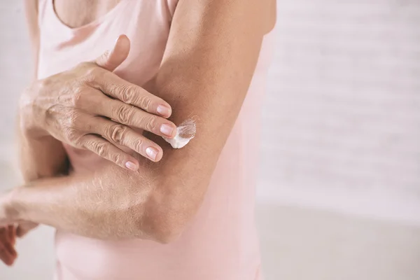 Woman applying body lotion — Stock Photo, Image