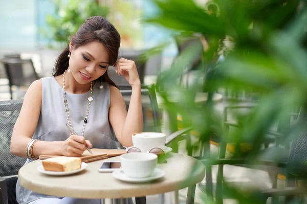 Mujer escribiendo ideas en bloc de notas —  Fotos de Stock