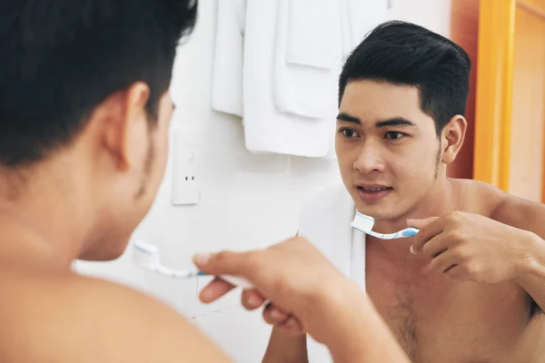 Man borstar tänderna i badrum — Stockfoto