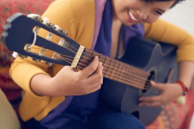 gülümseyen kadın gitar çalmak