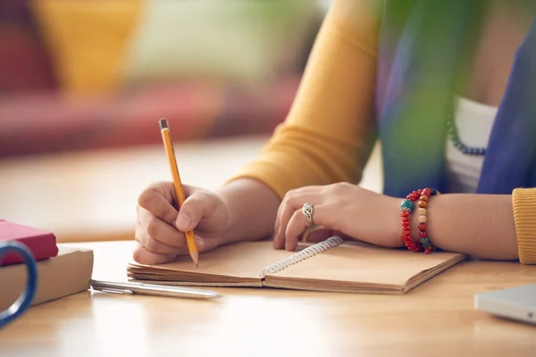 Kvinnlig hand skriva i lärobok — Stockfoto