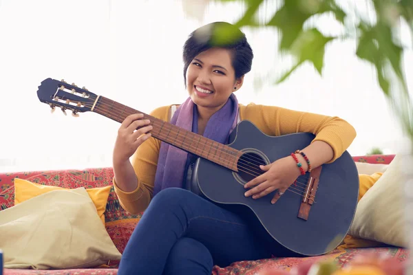 Mulher gostando de tocar guitarra em casa — Fotografia de Stock