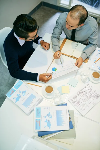 Mitarbeiter diskutieren Graphen und Diagramme — Stockfoto