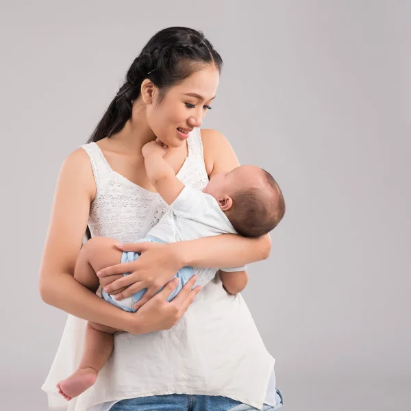 Mãe olhando para criança nas mãos — Fotografia de Stock