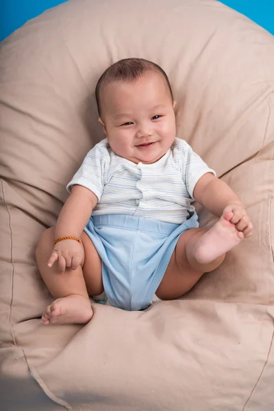 Lächelndes Kind im Bohnensack liegend — Stockfoto