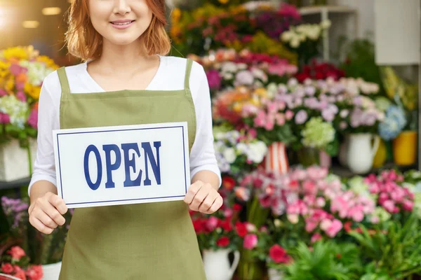 Floristería sosteniendo signo abierto — Foto de Stock