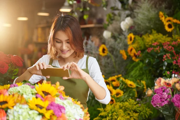 Kvinna med smartphone för att ta foto av blommor — Stockfoto