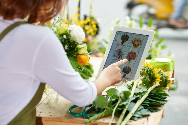 Fleuriste en utilisant l'interface du magasin de fleurs en ligne — Photo
