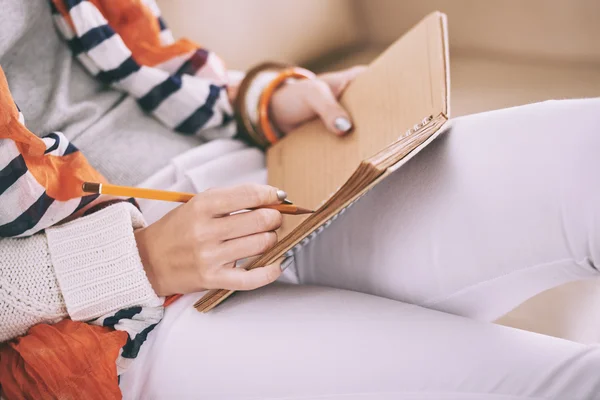 Frau schreibt Pläne in ihr Tagebuch — Stockfoto