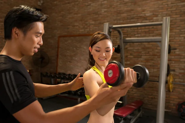 Trainer and woman working out with dumbbell — Stock Photo, Image