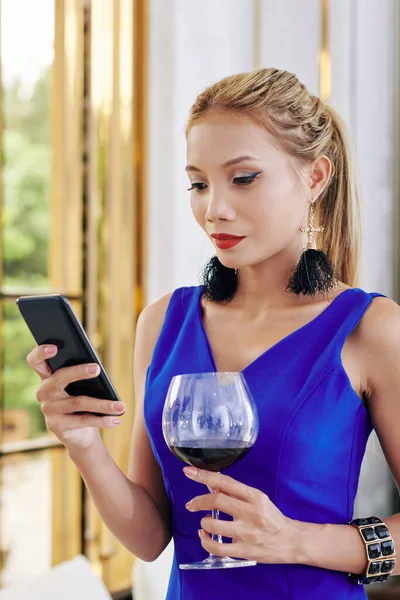 매력적 유행하는 여자가 와인을 마시고 친구들에게 문자를 보내다 — 스톡 사진
