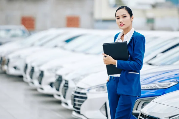 Portrait Confident Successful Saleswoman Leather Folder Hands Standing Car Dealership — Stock Photo, Image