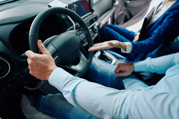 顧客と車のコンパートメントに座って 新しいモデルの利点を示す車のディーラーマネージャーのトリミング画像 — ストック写真