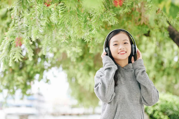 Portret Uśmiechniętej Wietnamki Słuchającej Muzyki Słuchawkach Podczas Spędzania Dnia Parku — Zdjęcie stockowe