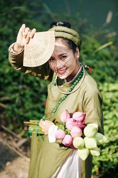 身穿传统服装的越南美女躲在雕刻的扇子后面的画像 — 图库照片