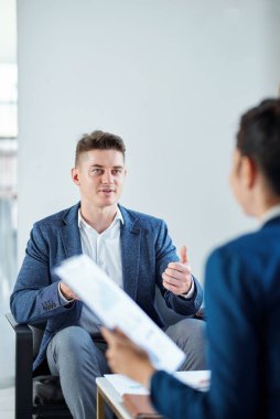 Yakışıklı genç girişimci toplantıda yöneticinin sorularını yanıtlıyor