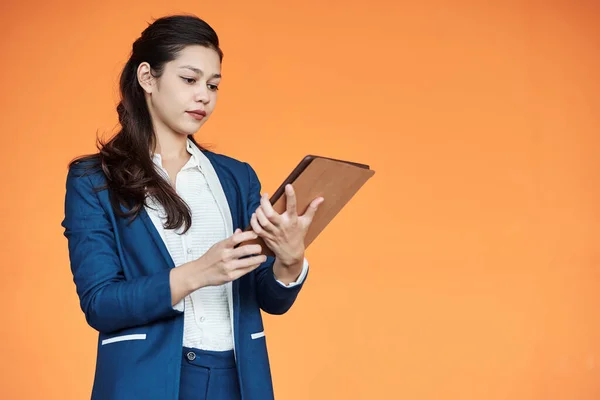 Serious Young Female Entrepreneur Reading Article Tablet Computer Isolated Orange — Stock Photo, Image