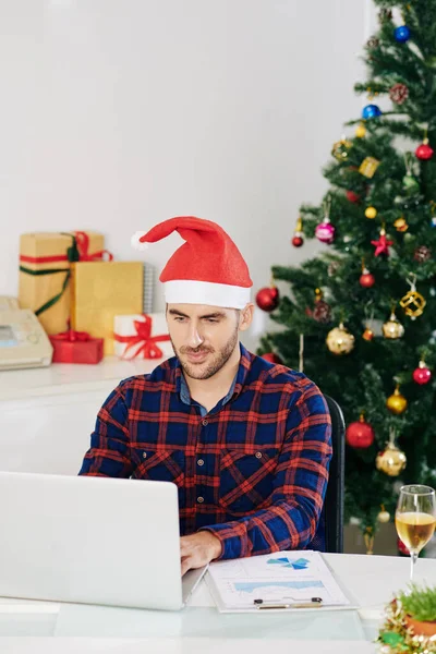 Usmívající Pohledný Mladý Podnikatel Santa Claus Klobouk Pracuje Notebooku Zdobené — Stock fotografie